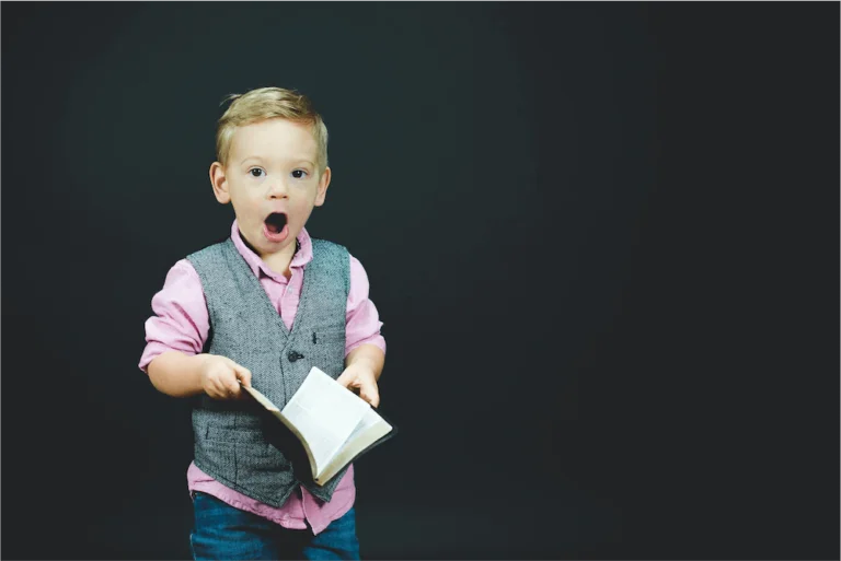 Enfant étonné qui a un livre dans les mains